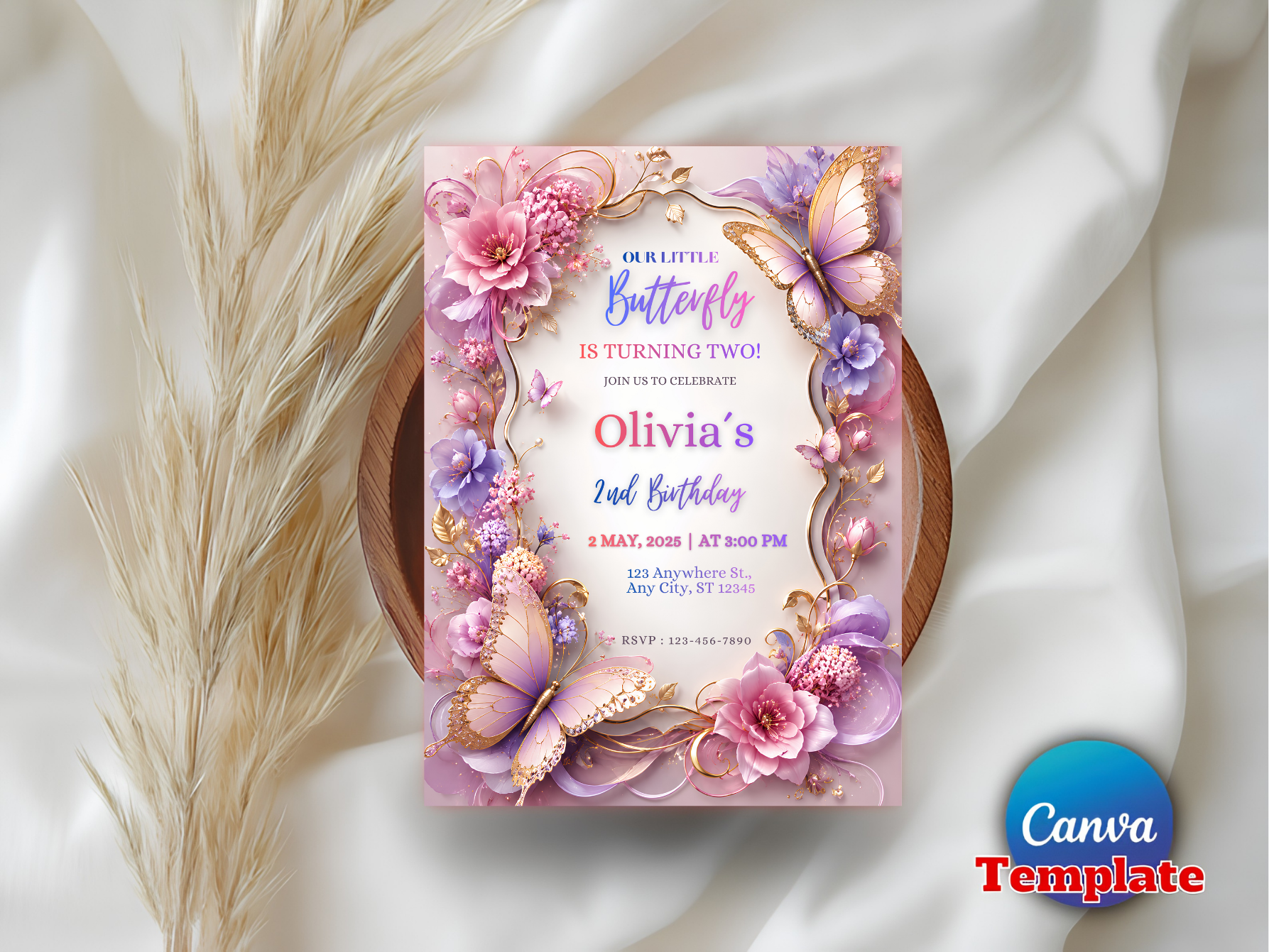 A decorative birthday invitation card with pink and purple floral borders, butterflies, and gold ornamental details, styled on a white draped fabric background with dried grass stems. A blue circular 'Canva Template' badge appears in the bottom right corner.