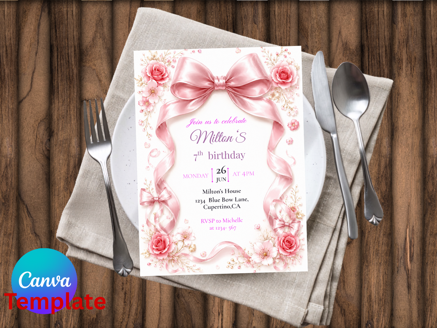 A pink floral birthday invitation card styled on a beige napkin with silver cutlery on a wooden table. The invitation features a large pink bow illustration and elegant text.