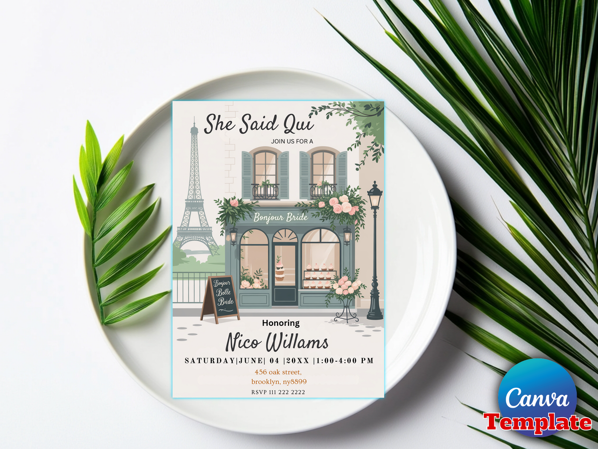 A square bridal shower invitation card displayed on a white plate, surrounded by green palm leaves on a white background. The invitation features an illustration of a Parisian-style boutique with the Eiffel Tower in the background, along with text reading 'She Said Oui' and 'Bridal Shower'.